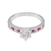 Yuki luxurious red gemstone ring with a large clear center stone and smaller red gemstones along the band
